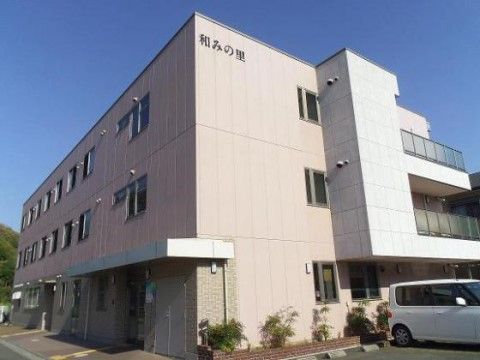 建物の最上階部分の壁に施設名が表示されているピンクの建物