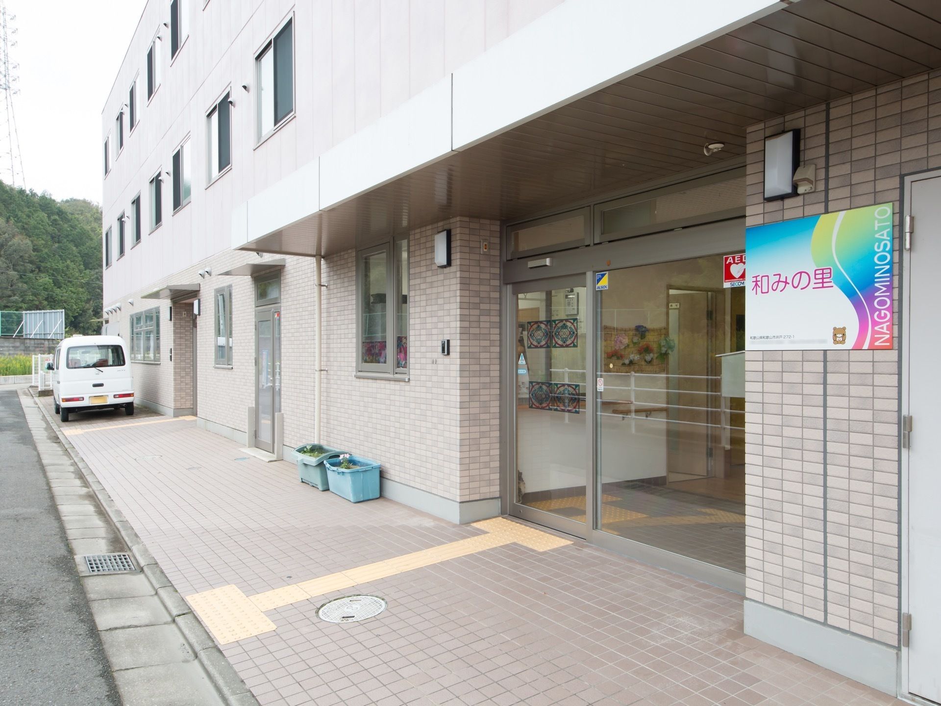 施設は３階建てで横に広い造りである。玄関の扉はガラス張りで、自動で開閉するようになっている。外壁には施設の看板がある。