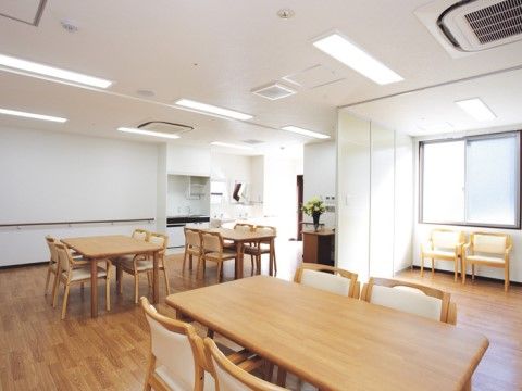 木製の４人掛けダイニングテーブルが３つ置かれた広間
