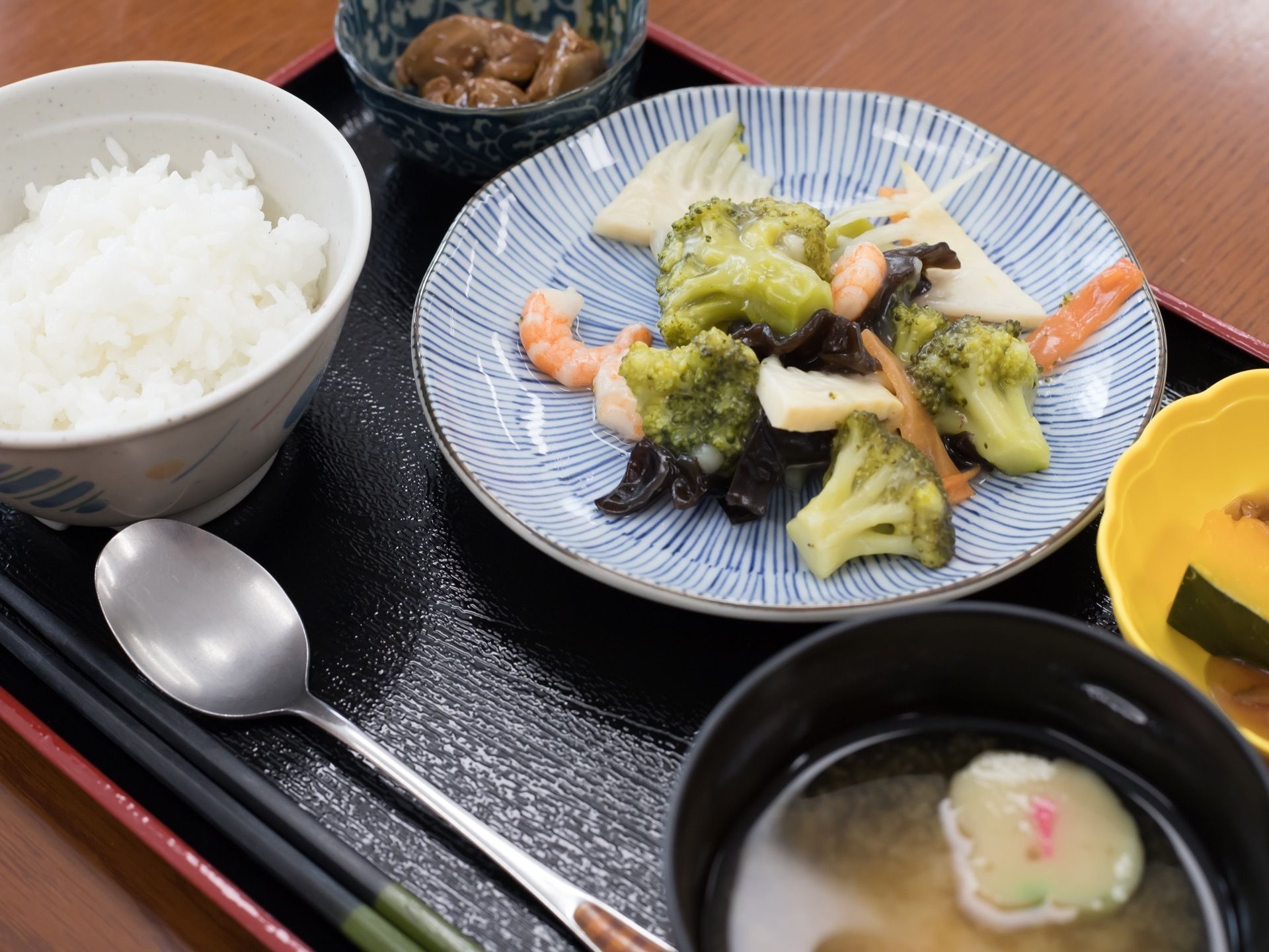 ブロッコリー、エビ、たけのこ、人参を炒めた栄養バランスの良い主菜に、ご飯や、お漬物、お味噌汁もついている。