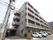 茶色を基調とした施設建物は、道路に面した場所に建てられている。建物前に、駐車スペースが設けられている。