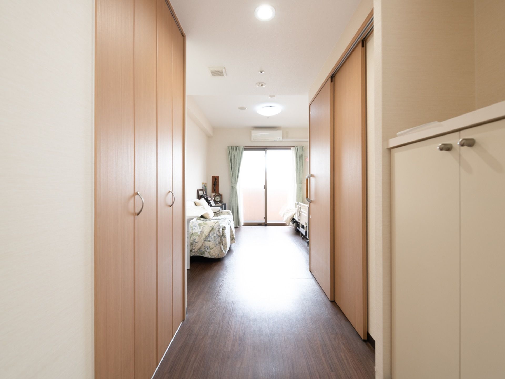 居室入口の右手に観音開きの収納がある。その奥にトイレのドアがあり、その向こうは居住スペースになっている。