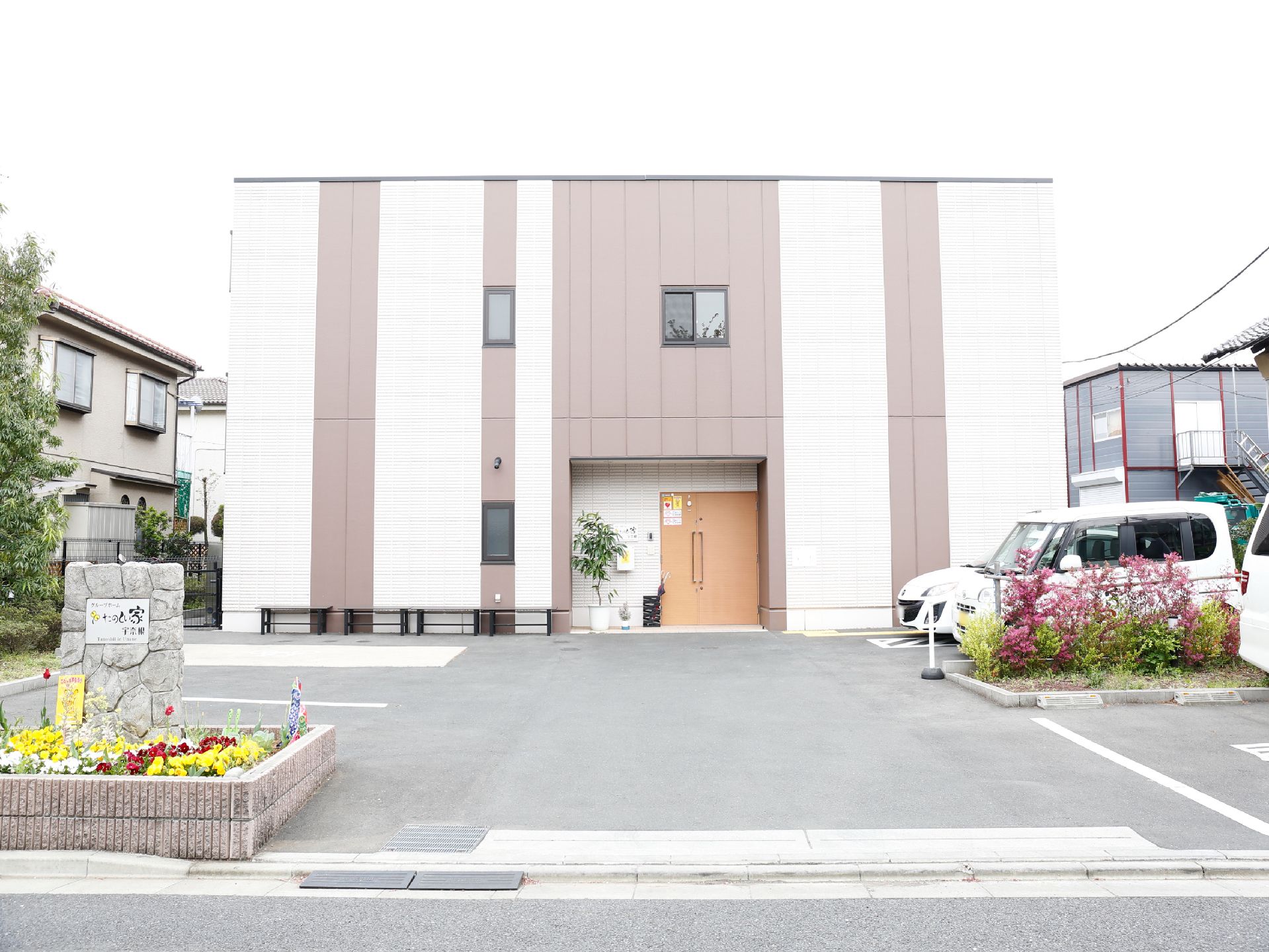 2階建ての建物で、玄関前のスペースがとても広く、駐車場も完備している。地面はフラットでバリアフリーである。