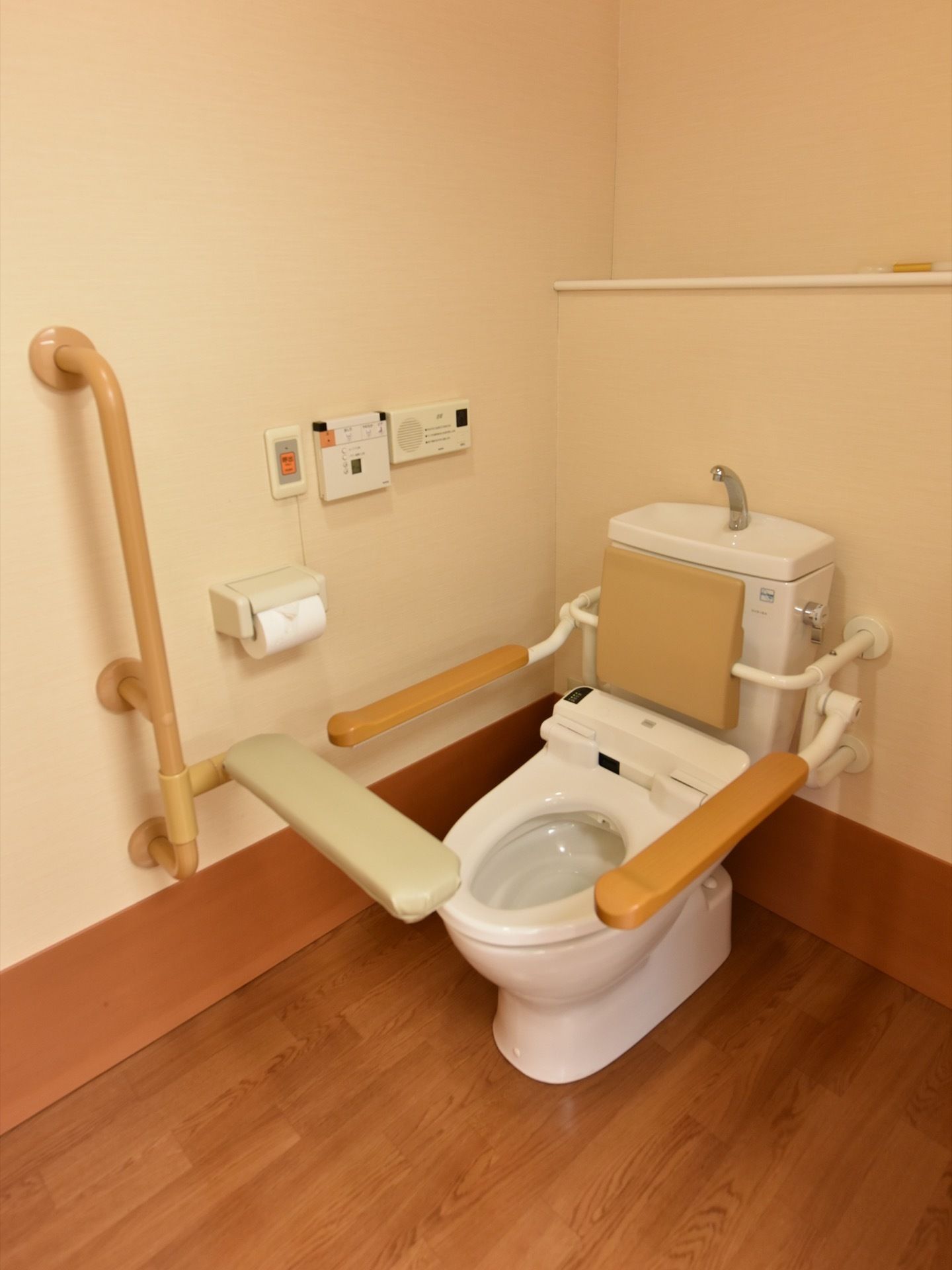 こちらは居室用のトイレ。洋式便器には、周りに手すりや背もたれが設置されている。ナースコールも取り付けられている。