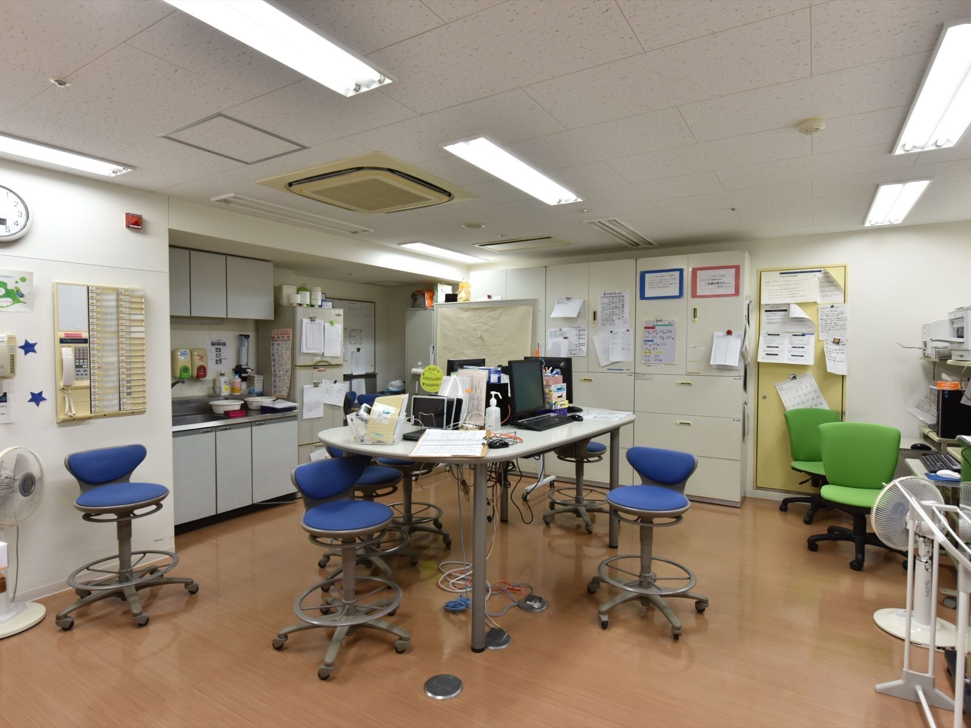 スタッフが待機している部屋である。キッチン、書類などが置かれている。パソコンが何台も設置されている。