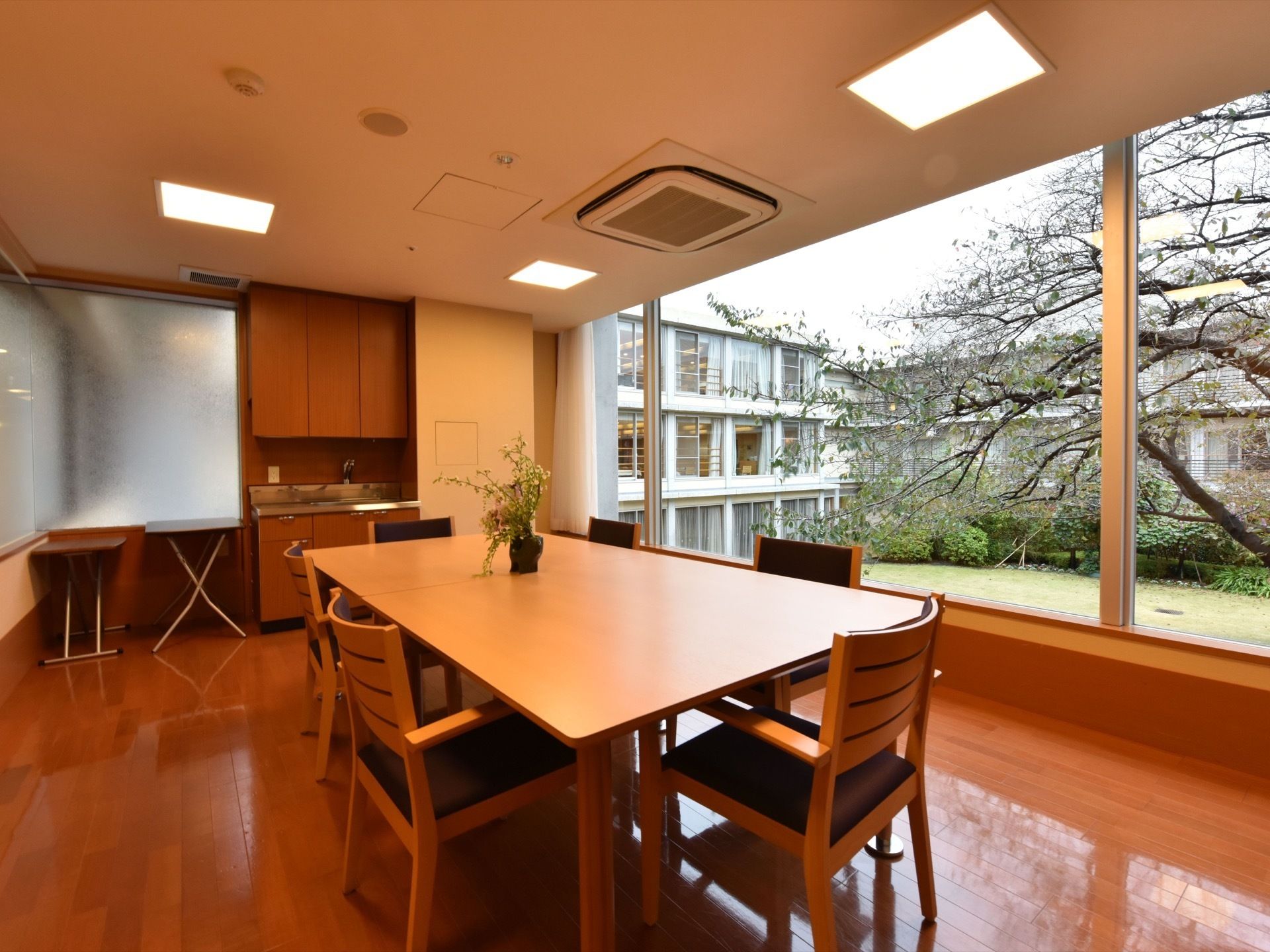 個室になっているこの部屋は、キッチンもついておりリビングのような印象を受ける。木のぬくもりを感じられる色合いの室内になっている。