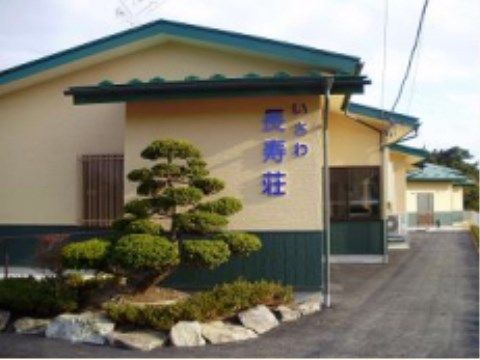 「いさわ長寿荘」の外観。畑、木々と自然に恵まれた環境を整えた平屋建ての和風チックな施設。