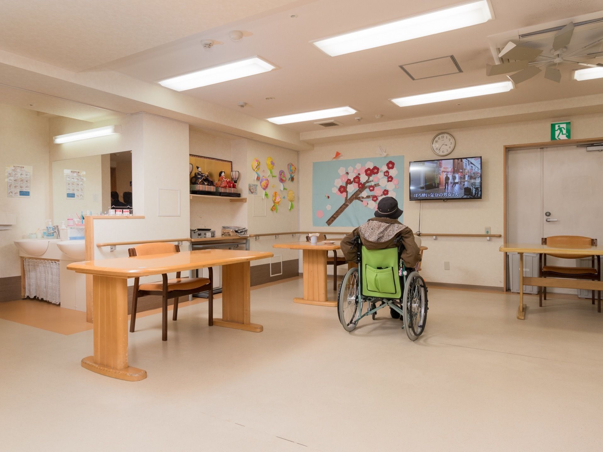 壁に手すりが続いている部屋である。テレビが壁に掛けられ、空いている壁には手作りの飾りが掛けられている。