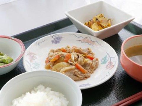 黒い和風のトレイにごはんやスープが配膳されている食事