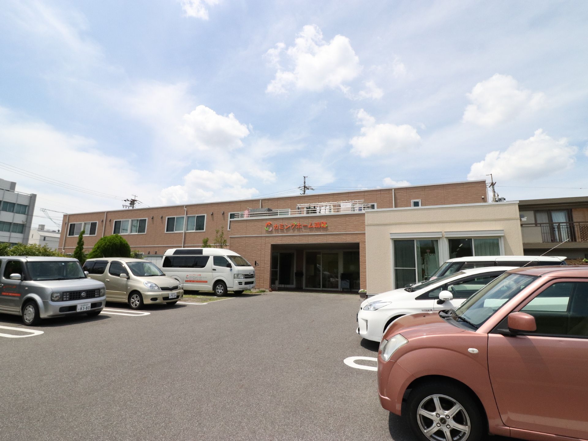 茶色の外壁で、落ち着いた雰囲気の2階建ての建物になっている。建物前には、広々とした駐車場があり、たくさんの車を停めることができる。