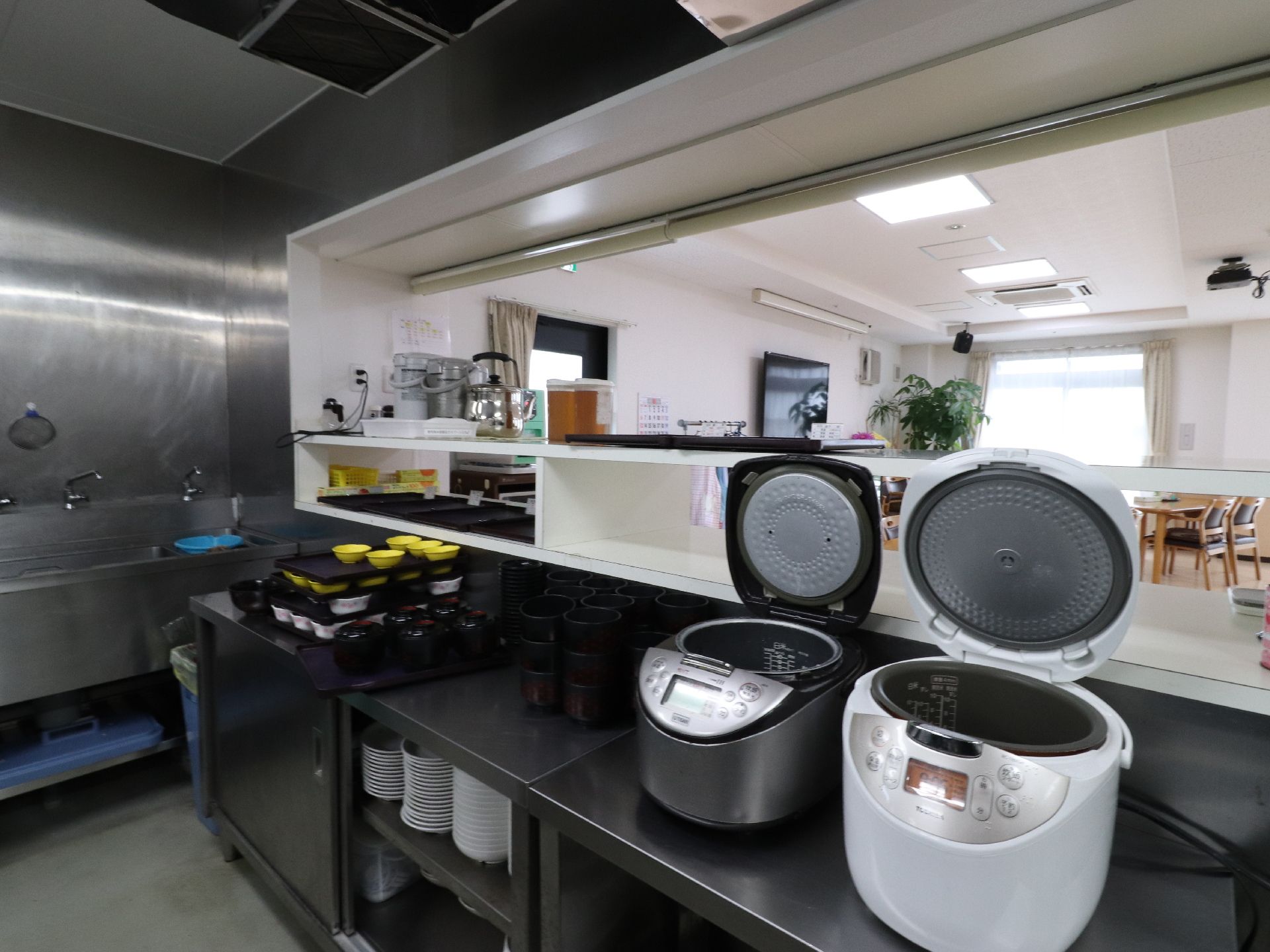 厨房カウンターの上には炊飯器が2台、お椀などが置かれている。下の部分にはお皿が収納できるようになっている。