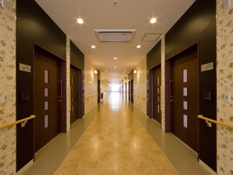 ローズガーデン葛原東の廊下。落ち着きあるホテルのような廊下は、通路幅が広く確保されており、車いすでのすれ違いも安心して行えます。