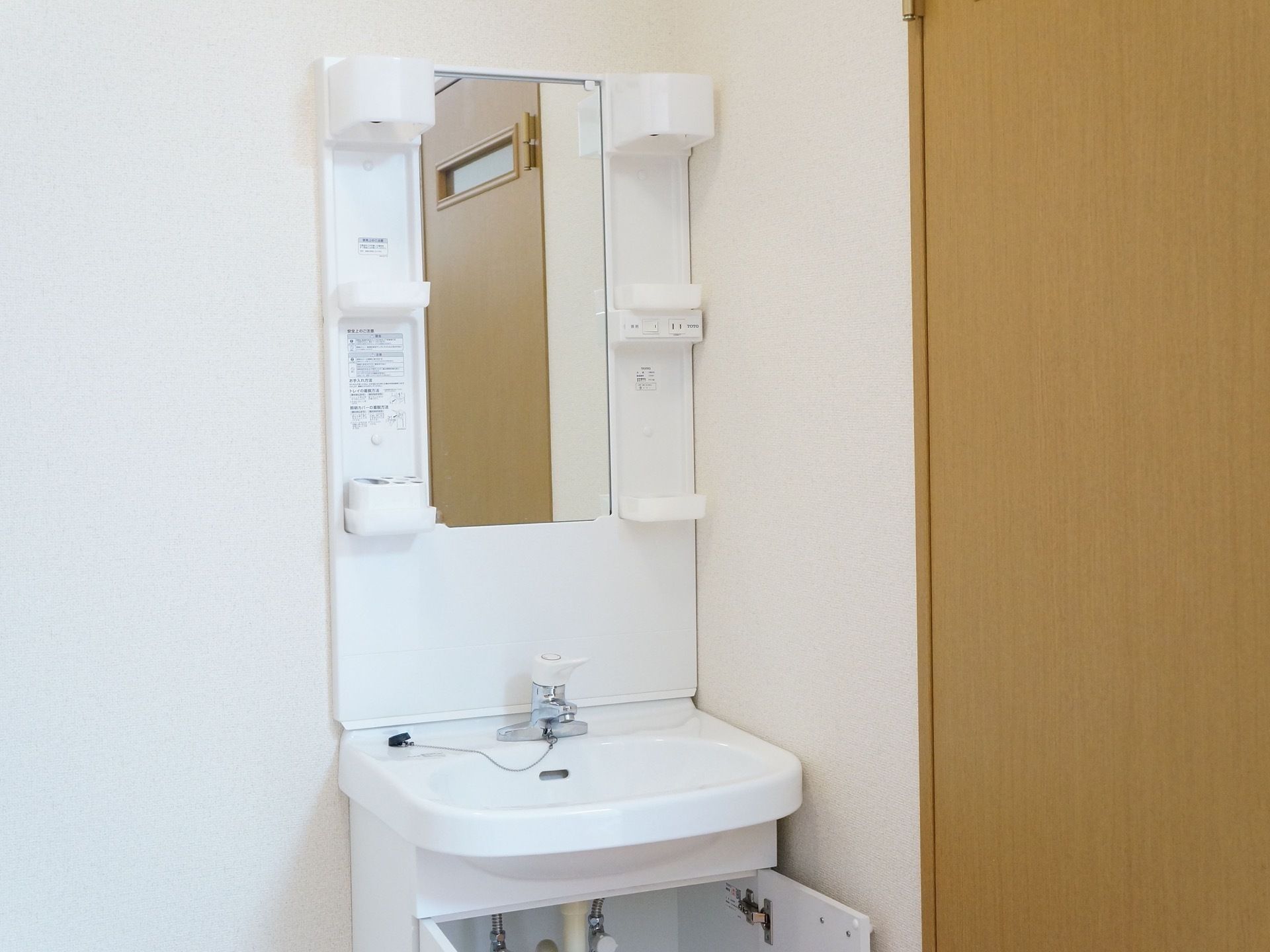 大きな鏡、照明の付いた洗面化粧台が居室に備え付けられている。収納のポケット、足元収納があるので整頓して使用ができる。