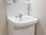 真っ白で清潔な洗面化粧台が備え付けられている。上部に収納ポケットがり、下部にも扉付きの収納があり、たっぷり入れられる。