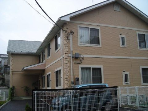 1台の車が止まっており、三角屋根が自宅を思わせる建物