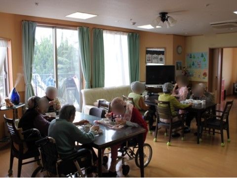 大きな窓があり、食事を楽しむ入居者様が集まったダイニング