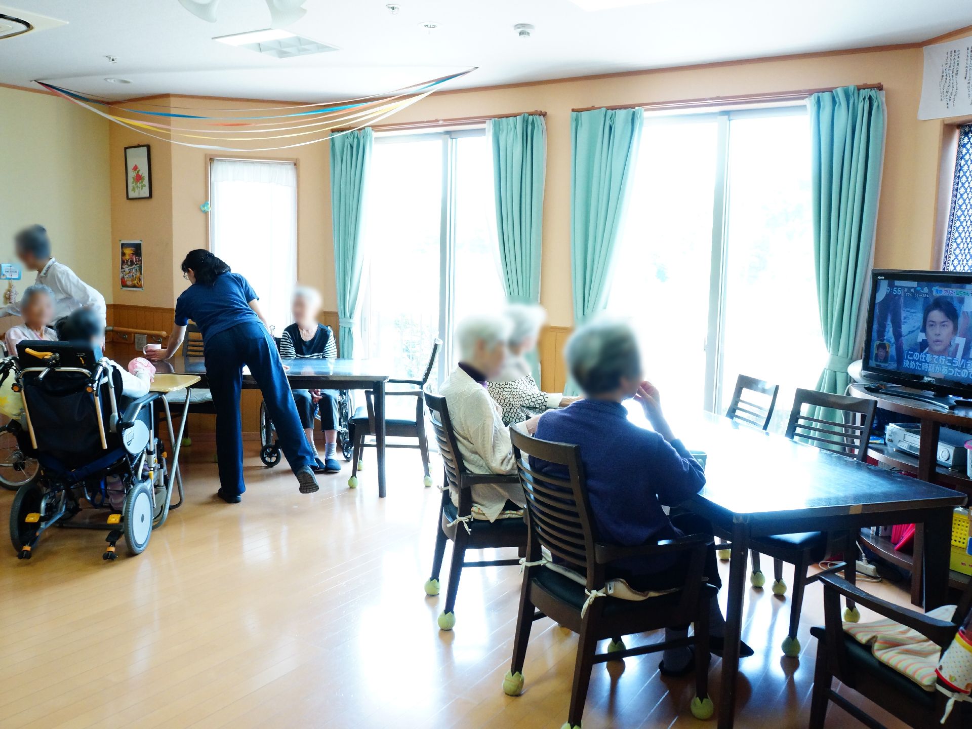食事でなくとも皆が集まってくる、居間兼食堂は施設入居者の憩いの場である。思い思いの団欒スタイルで寛いでいる・