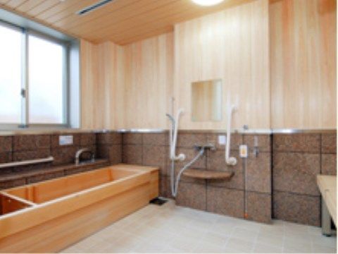 鏡の両側の壁に手すりが取り付けられた大浴場の洗い場