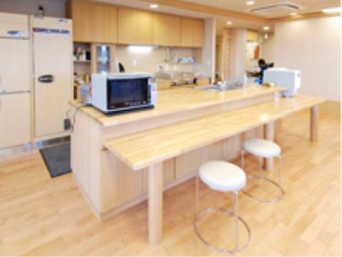 丸椅子が２脚置かれた木製テーブルがあるカウンターキッチン