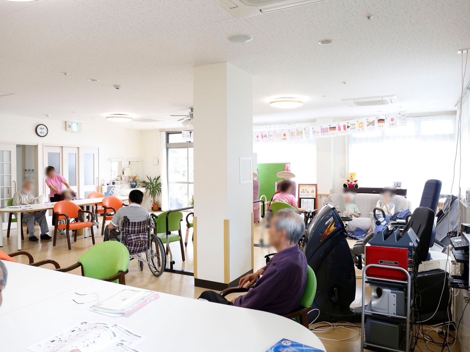 部屋の中心に太い柱があり、周りに椅子やテーブルなどが配置されている。テーブルの上に眼鏡と書類が置かれている。