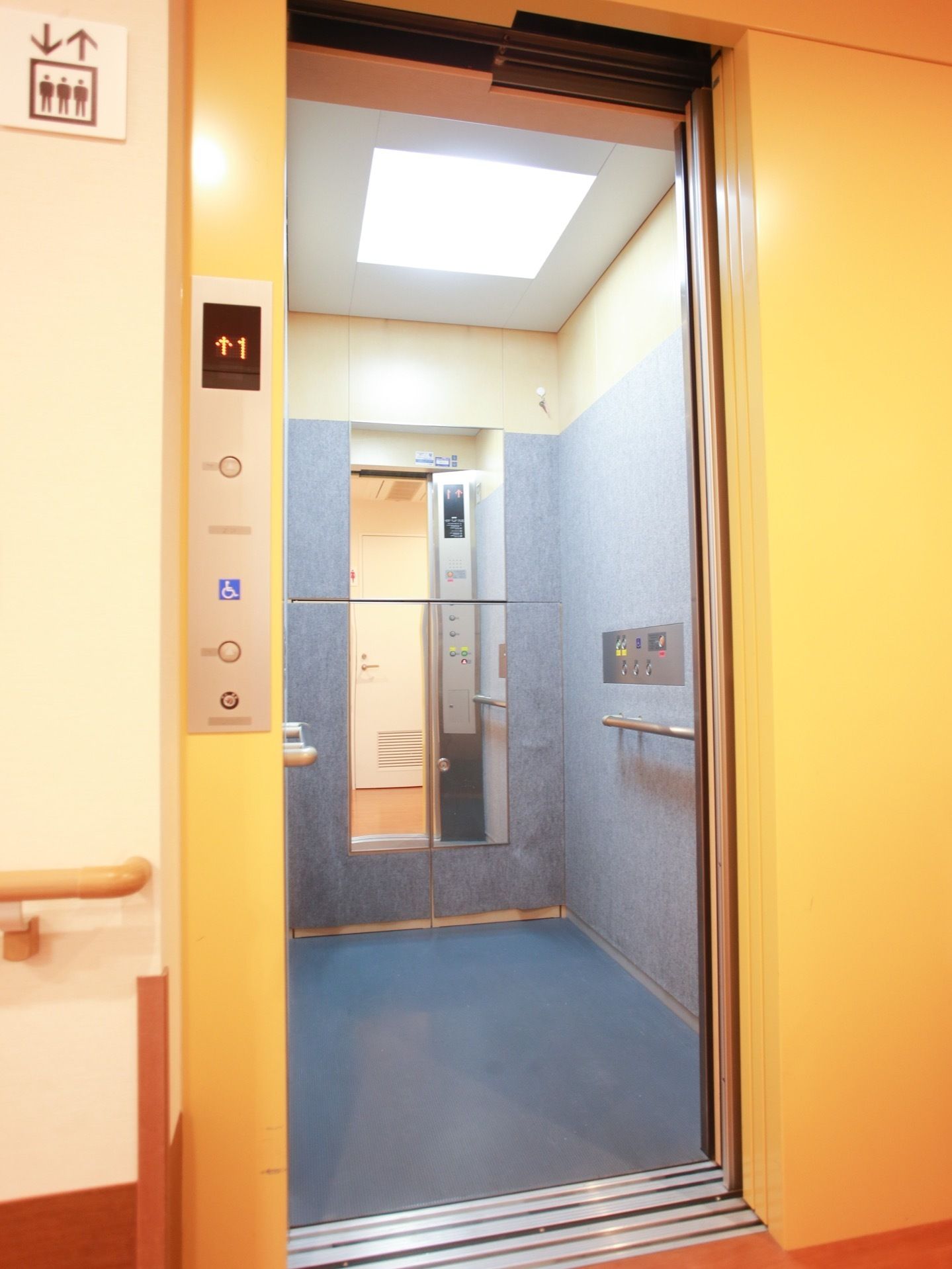 エレベーターの左上には人の絵が表示された看板が設置されており、一目にエレベーターと分かる表示になっている。