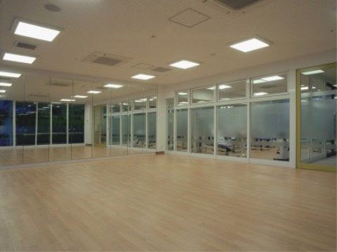 大きな鏡が奥の壁一面に広がっている、フローリングの広間