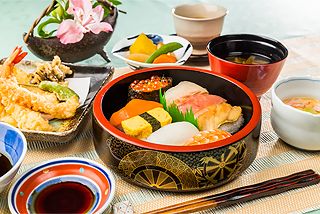 天ぷらの盛り合わせと握り寿司や軍艦巻きと野菜の煮物や吸い物のセット