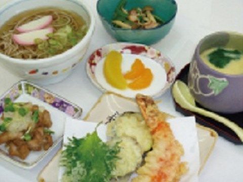 小さなお椀のお蕎麦をメインに、天ぷらや小鉢が添えられた食事