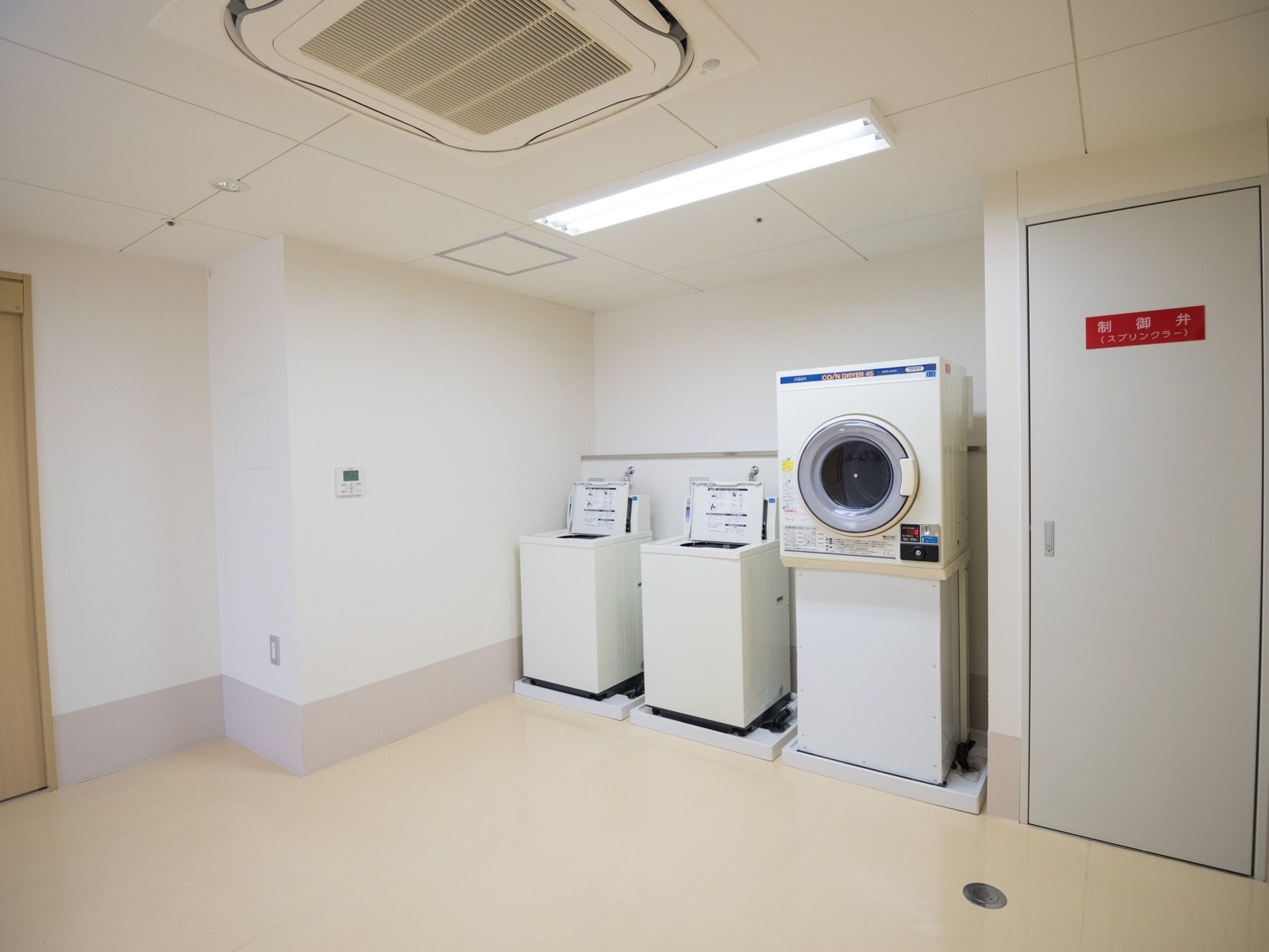 明るく広々とした室内の一角に、洗濯機と乾燥機が並んで配置されている。天候の悪い日でも乾燥機があるので、洗濯することができる。