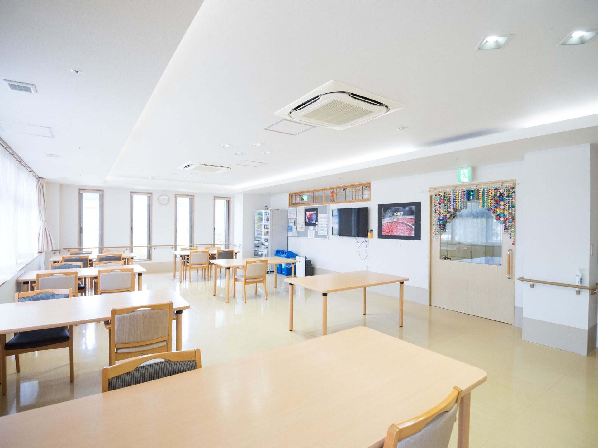 食堂には窓を多く取り付けて、外の日の光を室内に多く取り込めるようになっている。広々とした部屋には、テーブルが間隔を開けて多数設置されている。
