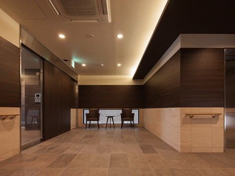 壁に手すりが設置され奥に椅子が配置された通路