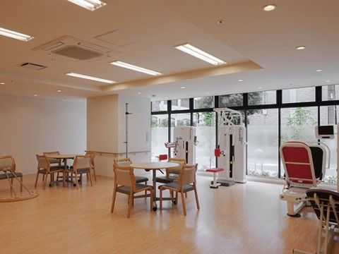 テーブルセットとトレーニングマシンが設置された共有スペース