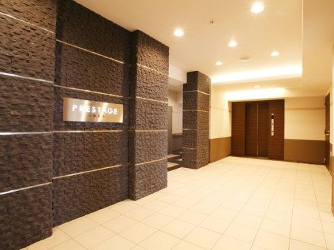 黒い壁に施設名が表示されたパネルが取り付けられたエントランス