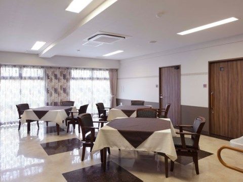「プレステージ小幡緑地」の娯楽室。テーブルや椅子が並んでいる。