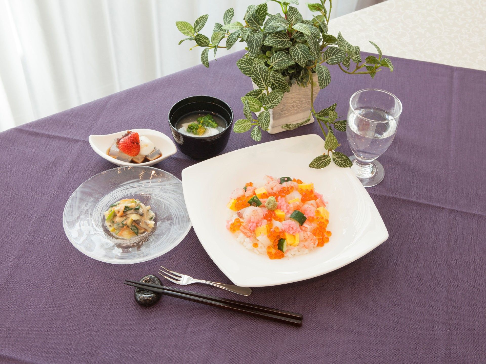 四角い白いお皿にちらし寿司が盛りつけられた和風の食事