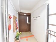 通路の壁には非常用の警報機が付いた赤いボタンがある。鯉のぼりやプランターに植えられた花など季節を感じられるものが置かれている。
