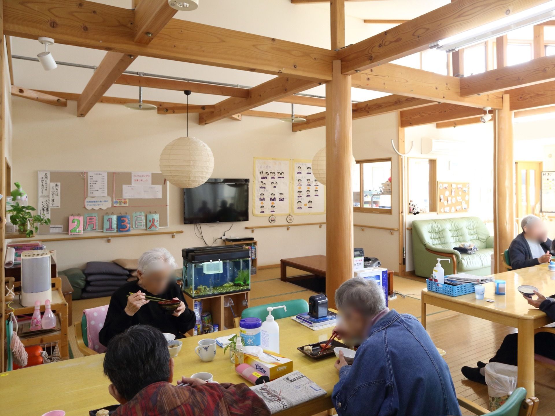 机と椅子が並んだ食堂。奥には、和室が広がっている。その他、木製の柱や梁からあたたかみを感じられるスペース。