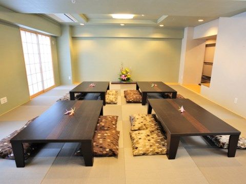 座布団が置かれたダークブラウンの座卓が４つある和室