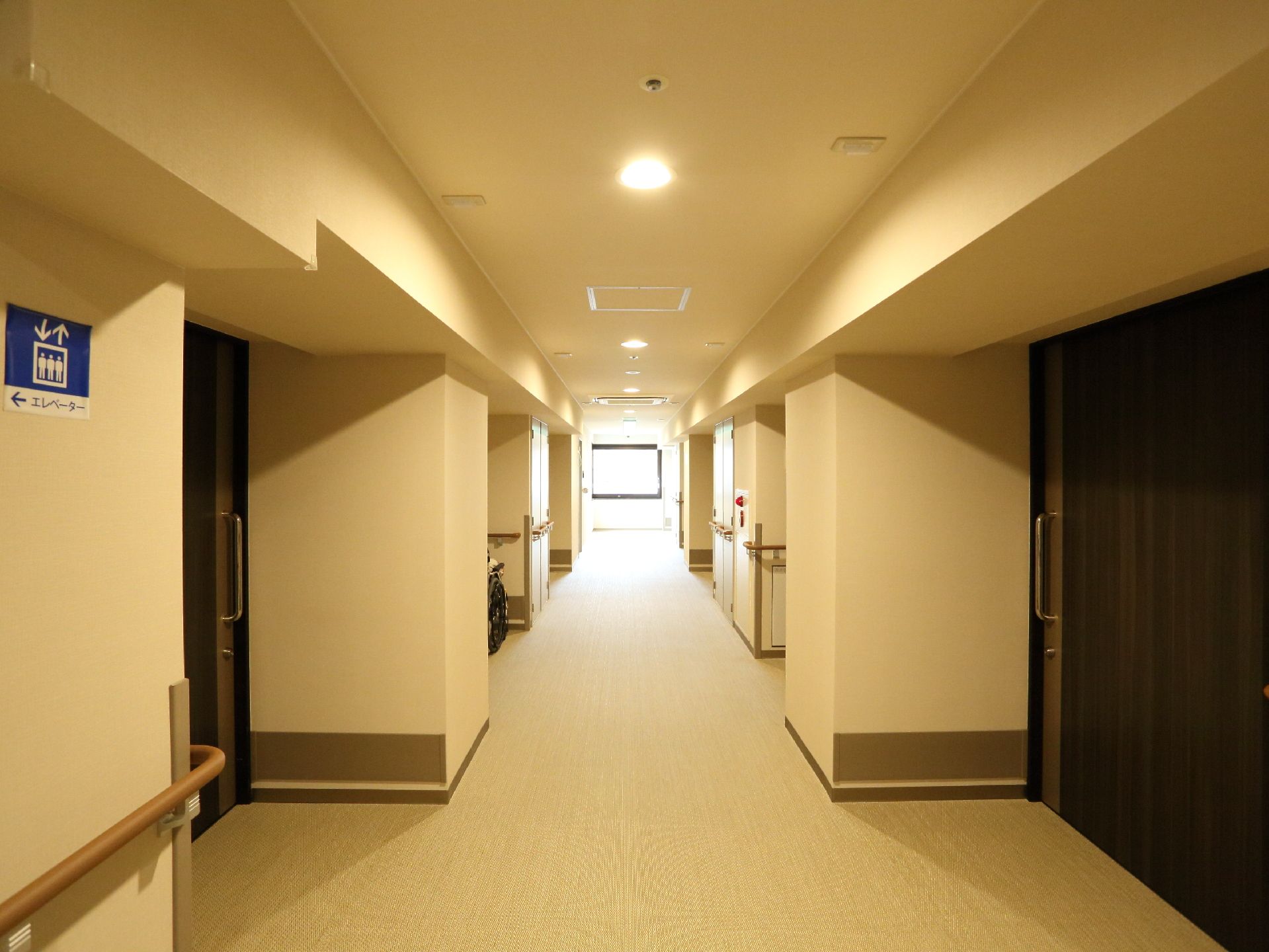 廊下の両端には、手すりが付けられていて、広めの造りになっている。部屋の扉は全て大きめの引き戸になっている。壁には消火栓もある。