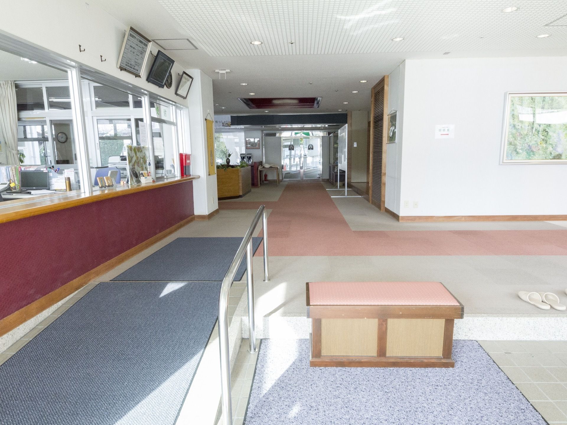 エントランスには事務所があり、24時間体制でスタッフが常駐している。通路は幅が大変広く、中央には太いピンクのラインが記されている。