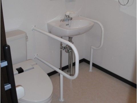 「終の棲家 桃の郷 別館３」のトイレ。洗面台の下はフットレスで、車椅子の足下接触防止に貢献している。