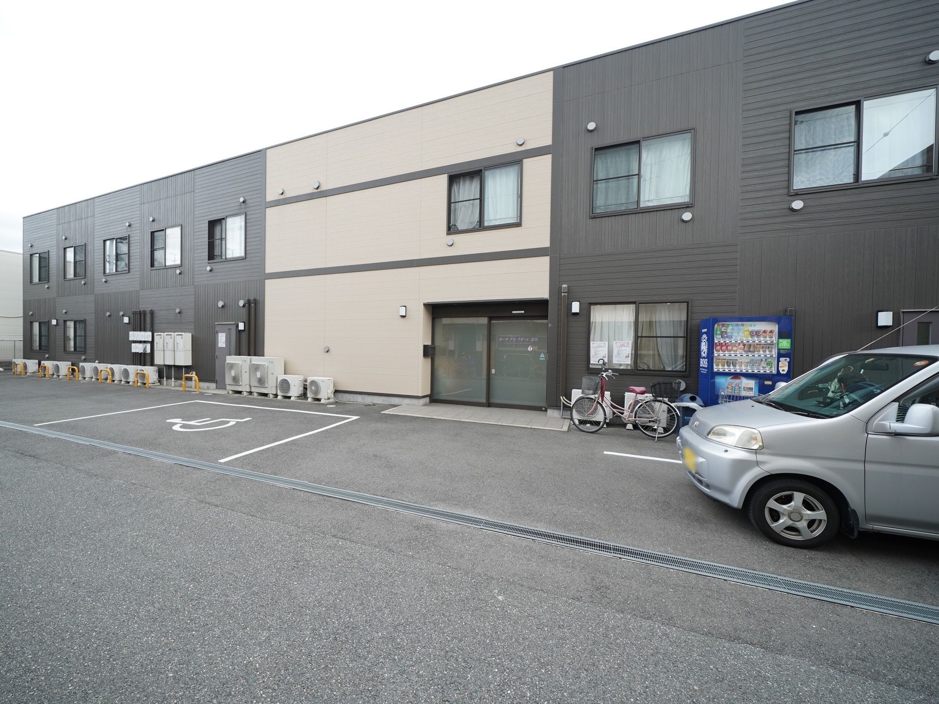 施設は黒やベージュを基調とした、落ち着いた雰囲気の２階建ての建物である。車椅子をご利用の方が同乗した車専用の駐車スペースがある。