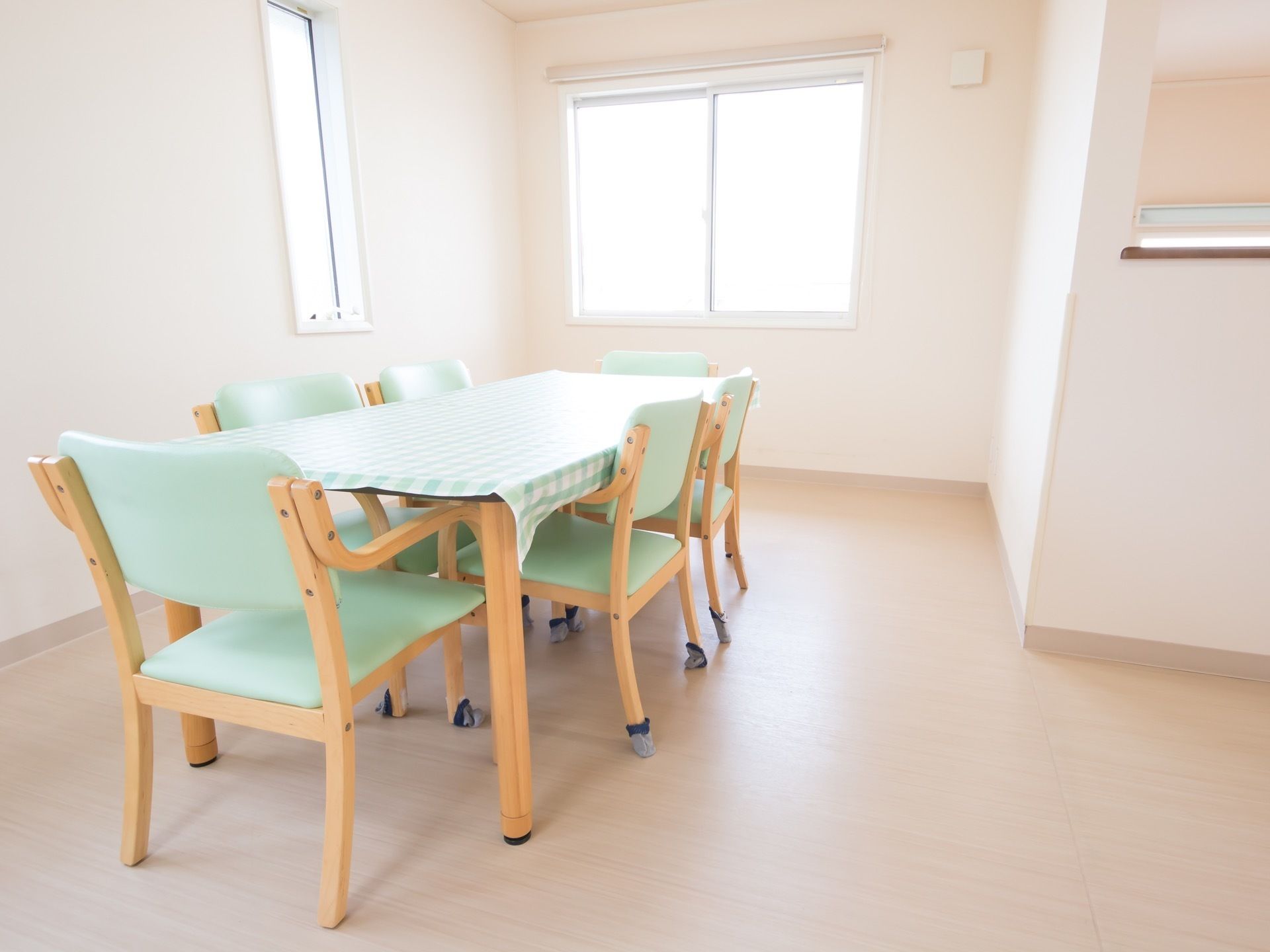 白い壁、薄いナチュラル色のフローリングである。部屋の中央には１台のテーブルと６脚の椅子が用意されている。