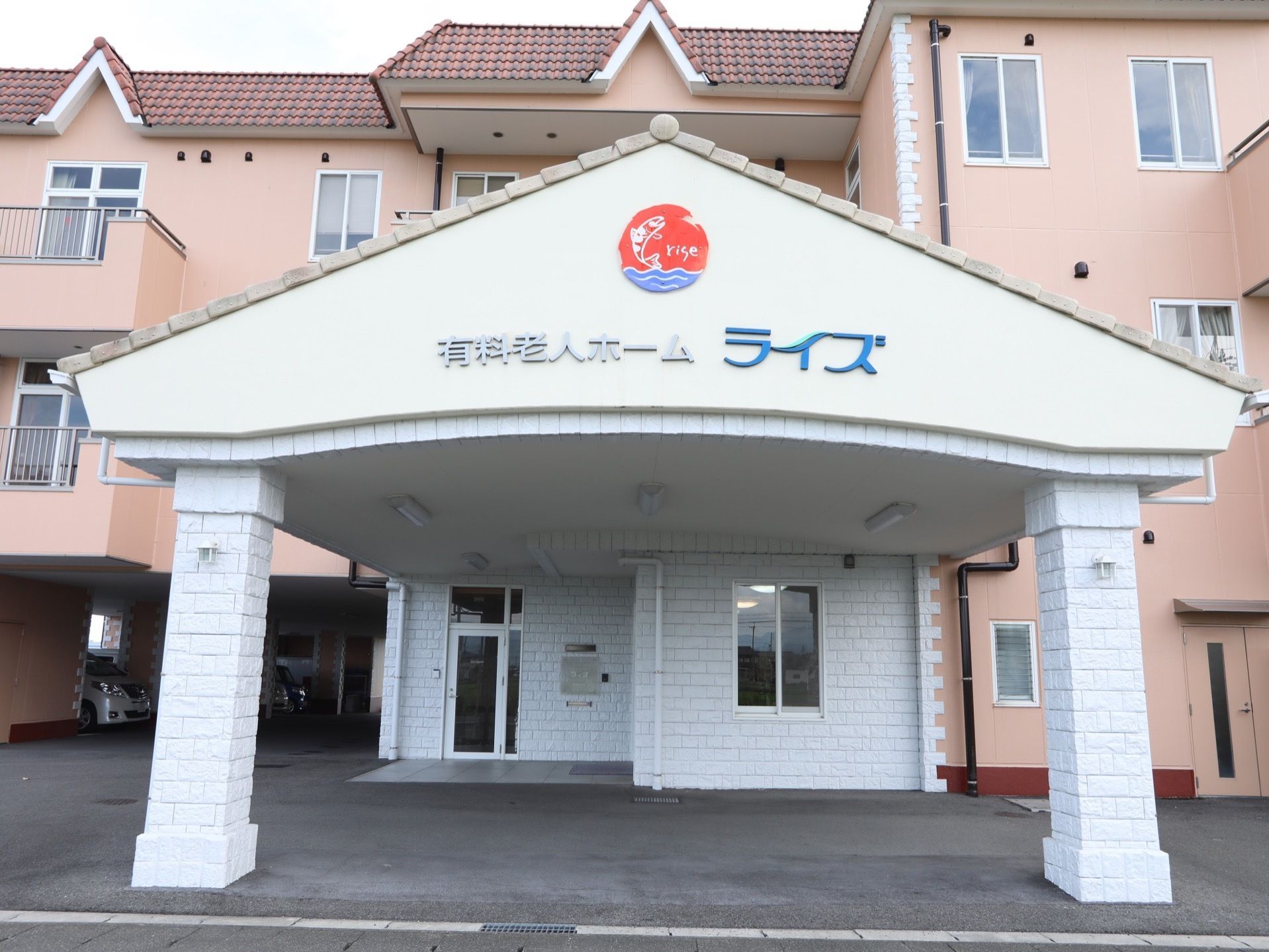 施設の建物は西洋風の３階建てである。玄関先に車寄せにもなっている三角屋根のひさしが長く伸びている。ひさしの屋根の下に施設名が入っている。