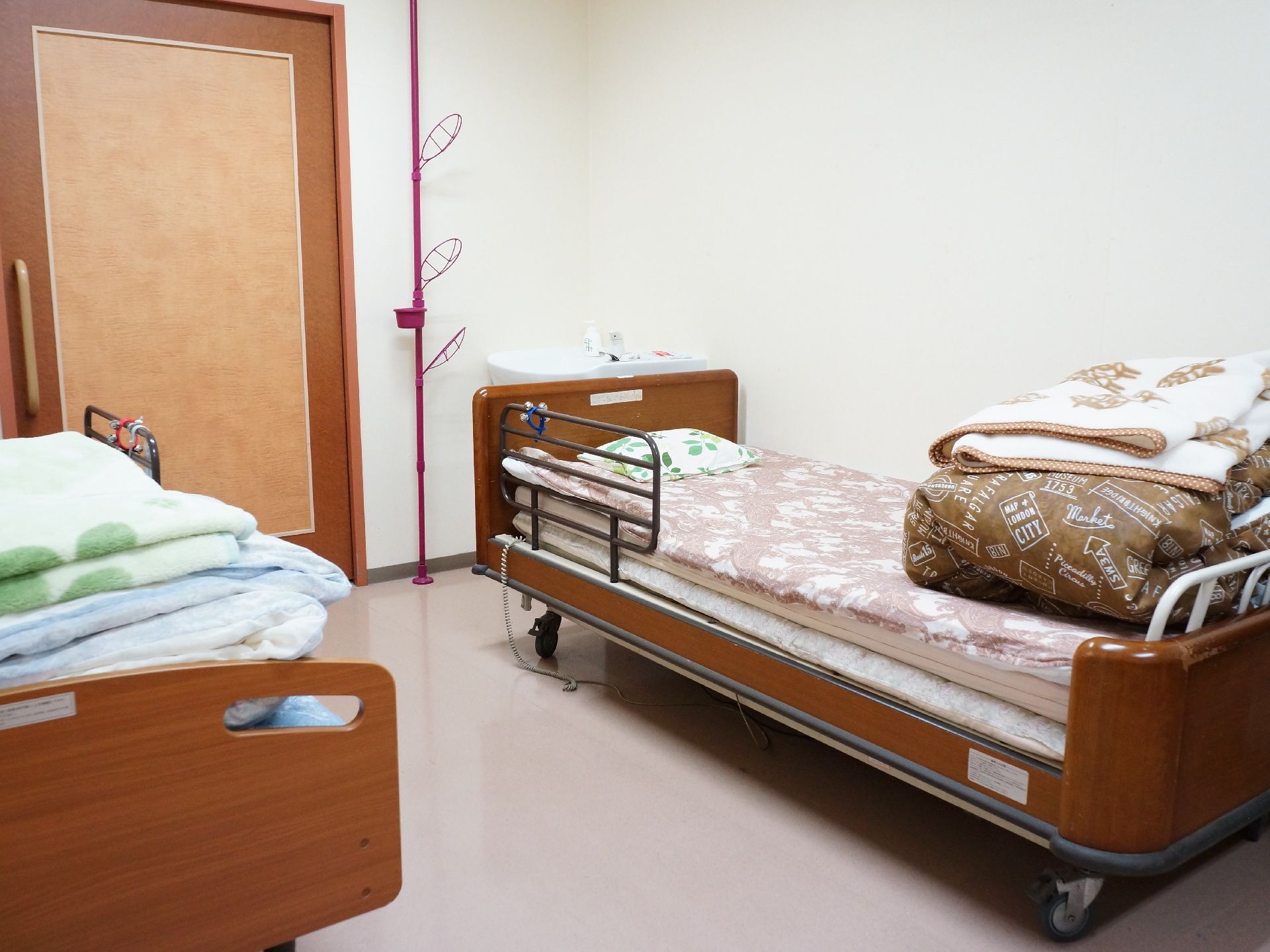 居室の扉は利用しやすい引き戸を採用。ベッド近くに、ハンガースタンドを設置している。毛布と掛け布団が用意してあり、温度を調節しやすい。
