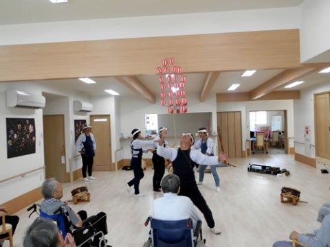広間で開催されている太鼓のパフォーマンスを見る入居者様