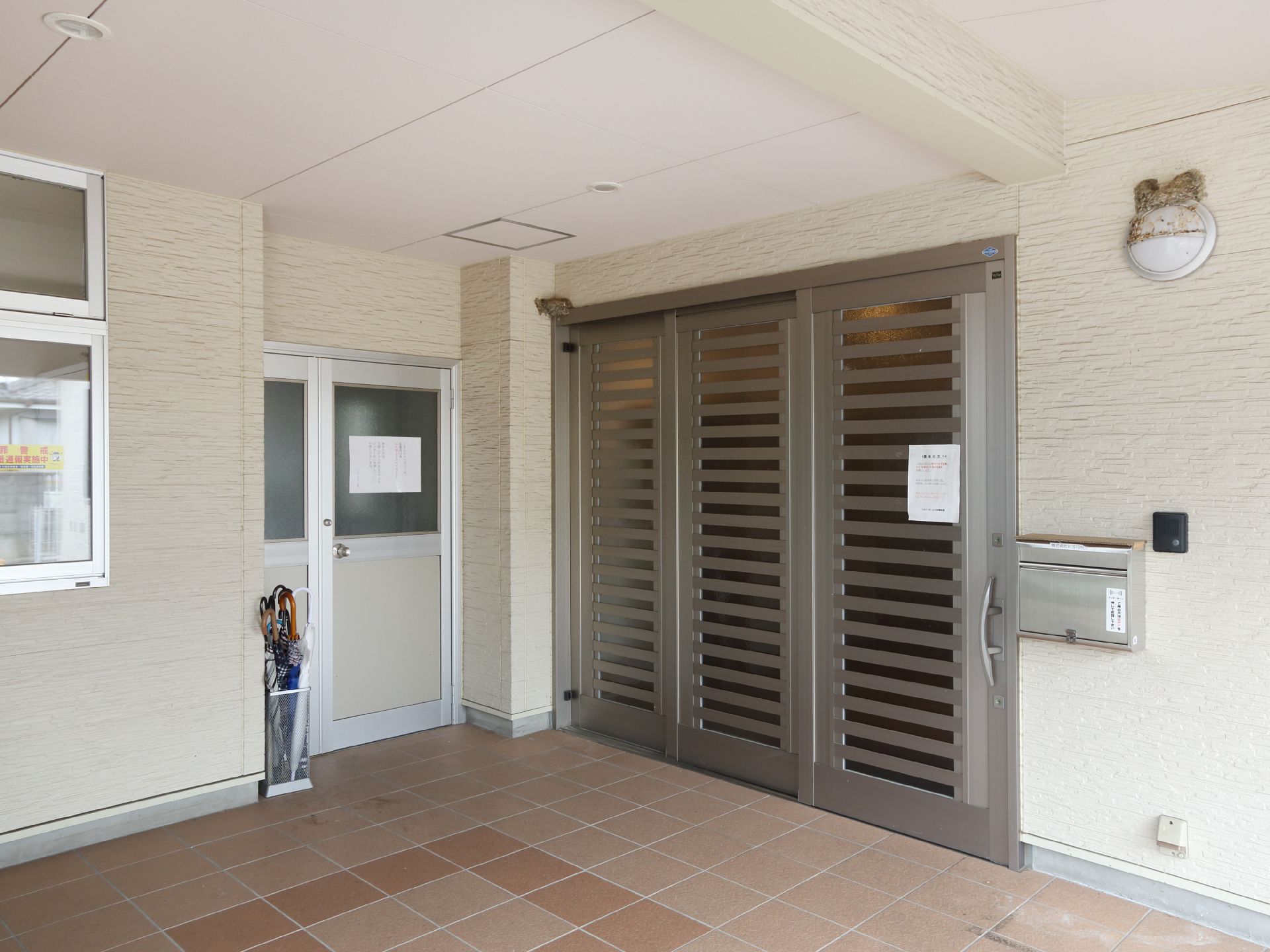 建物の入口は3枚扉の引き戸になっているので、大きく開く。入口前はタイル敷きになっていて大きな屋根もついている。