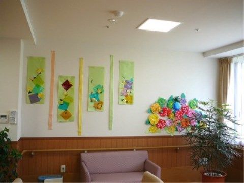 黄色や赤の紙で作られた花などが壁に貼られた共有スペース