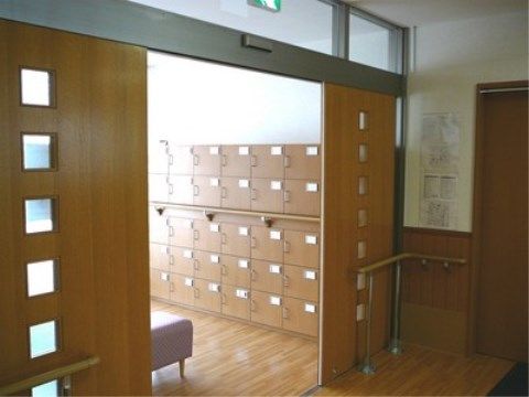 開いたままの自動扉の奥に下駄箱がたくさん並ぶエントランス