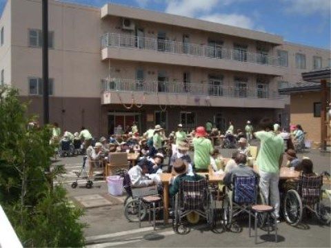 施設前の駐車場で開催されるイベントに参加する入居者様